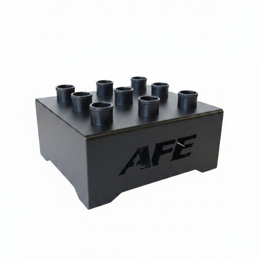 Black metal component with 'AFE' branding on a concrete floor in an industrial setting.
