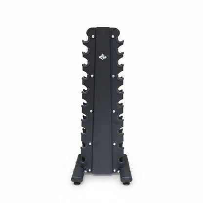 A black metal upright rack with multiple peg slots, standing on a concrete warehouse floor with shelves and stacked cardboard boxes in the background.