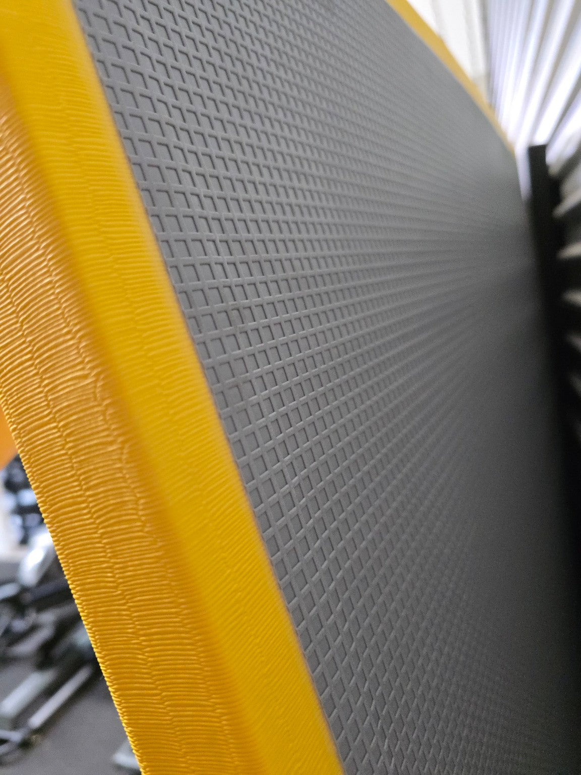 Gray mat with yellow border on a blurred background