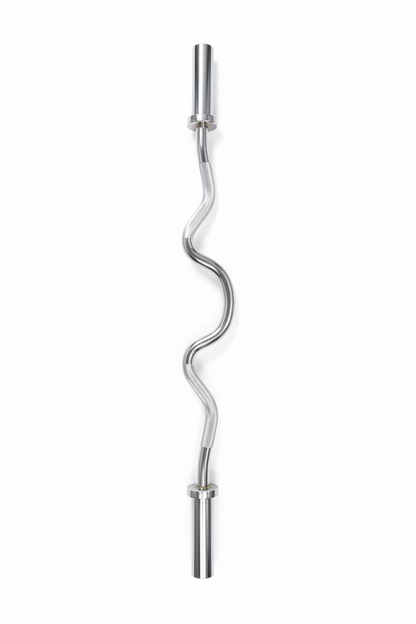 A curved steel barbell with a polished metallic finish, placed diagonally on a gray wood-look laminate floor.