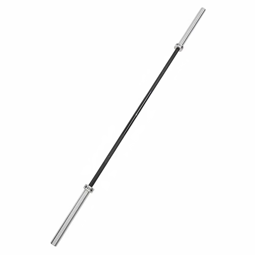 A silver metal barbell with black weight plates lies on dark gray gym floor tiles, with other gym equipment partially visible in the background.