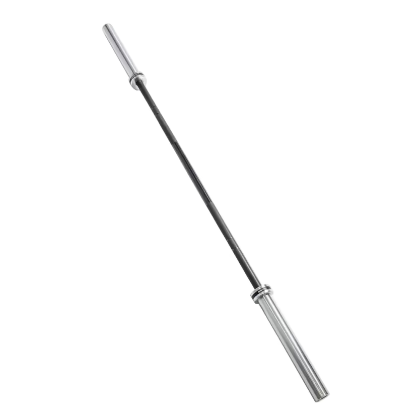 A silver metal barbell lying diagonally on dark gray gym floor tiles, with part of a black weight rack visible in the upper right.
