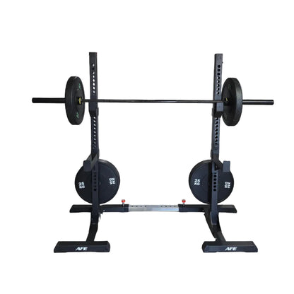 A pair of black AFE squat racks holding 225 lbs plates, set in a gym with a white sheet covering equipment in the background.
