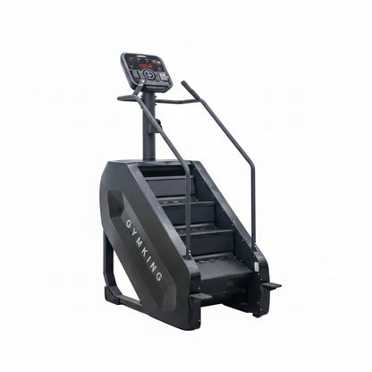 A black stair climber exercise machine with a digital display screen and handrails, positioned against a plain light gray wall and concrete floor.