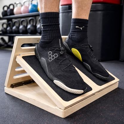 Person using a wooden step platform in a gym setting