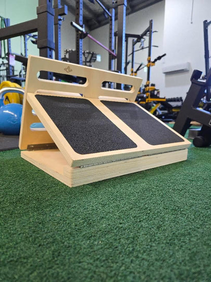 Wooden step platform with black surface in a gym setting